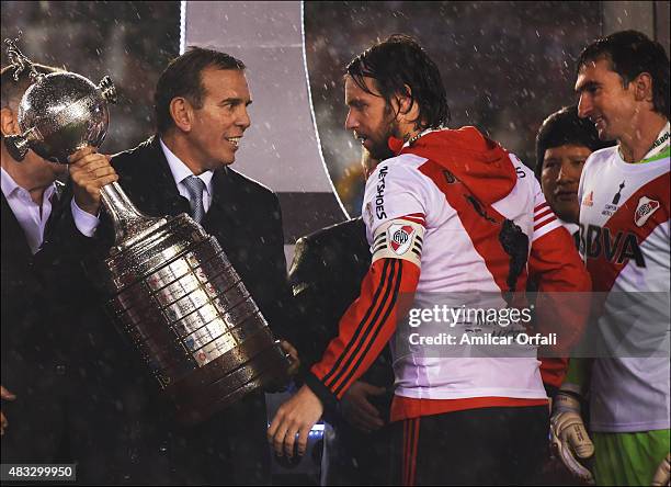 Fernando Cavenaghi of River Plate receives the trophy from Carlos Naput after winning a second leg final match between River Plate and Tigres UANL as...