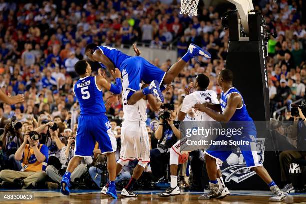 Alex Poythress of the Kentucky Wildcats falls over DeAndre Daniels of the Connecticut Huskies during the NCAA Men's Final Four Championship at AT&T...