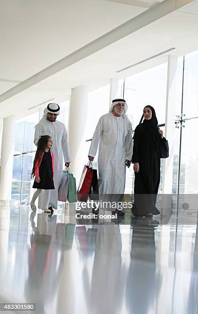 arab family in shopping center with bags - emirati family shopping stock pictures, royalty-free photos & images
