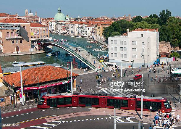 Tram crosses in front of view the Calatrava bridge and the Hotel Santa Chiara newly built extension on August 7, 2015 in Venice, Italy. The unveiling...