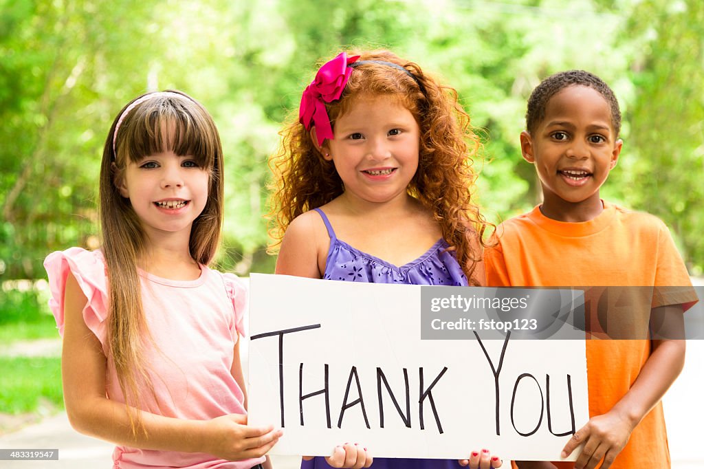 Volunteerism:  Three precious children holding a Thank You sign. Charity.