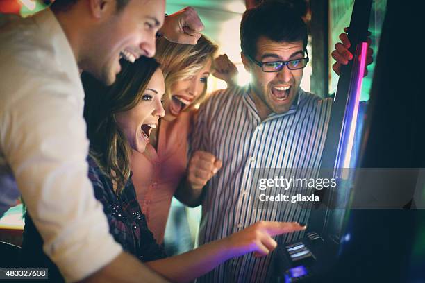 grupo de adultos jóvenes divirtiéndose en el casino. - sala de máquinas recreativas fotografías e imágenes de stock