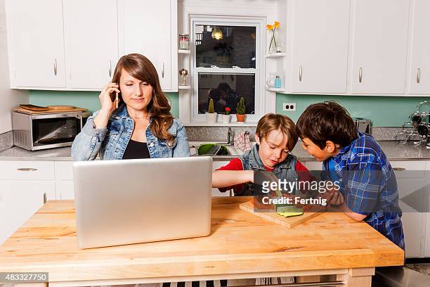 madre lavorando da casa la sera - family with two children foto e immagini stock