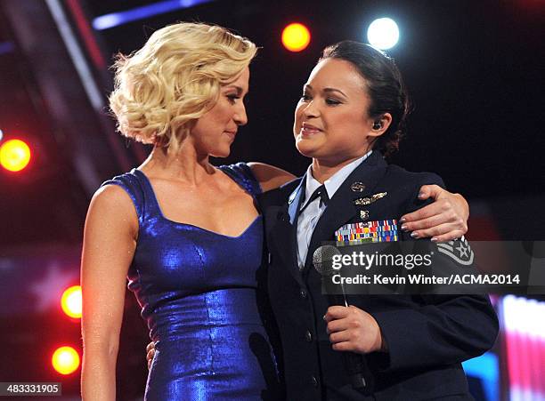 Singer Kellie Pickler and Staff Sgt. Baily Zimmerman perform onstage during ACM Presents: An All-Star Salute To The Troops at the MGM Grand Garden...