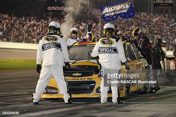 The pit crew for the Caterpillar Chevy SS, driven by Ryan Newman, works to repair damage to the car during the running of the Daytona 500 at the...