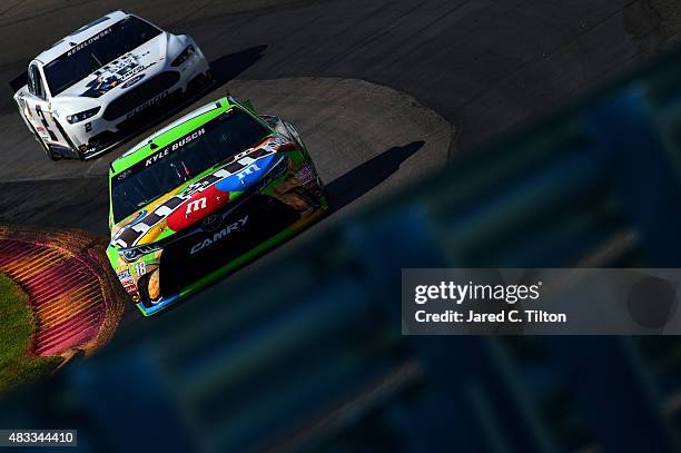Kyle Busch, driver of the M&M Crispy Toyota, leads Brad Keselowski, driver of the Miller Lite/Luke Bryan Ford, during practice for the NASCAR Sprint...