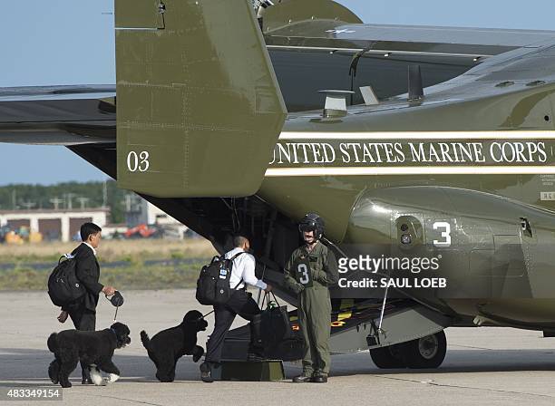President Barack Obama's dogs, Bo and Sunny, board a US Marine Osprey helicopter to travel from Cape Cod Coast Guard Air Station to Martha's Vineyard...