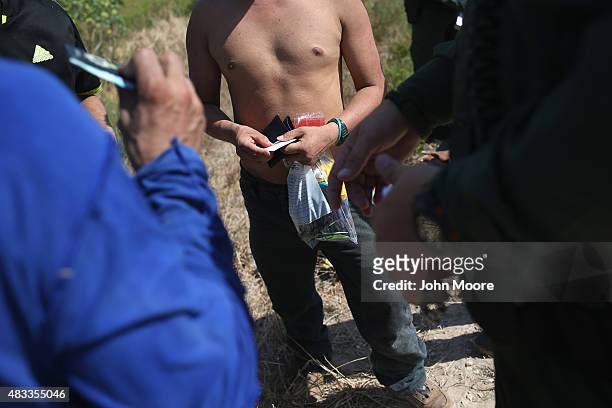 Border Patrol agents detain undocumented immigrants after they crossed the border from Mexico into the United States on August 7, 2015 in McAllen,...