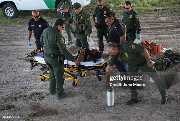 Paramedics and U.S. Border Patrol agents assist an undocumented immigrant after he collapsed from heat exhaustion after crossing from Mexico into the...