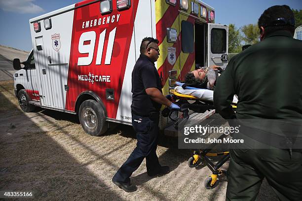 Paramedics and U.S. Border Patrol agents assist an undocumented immigrant after he collapsed from heat exhaustion after crossing from Mexico into the...