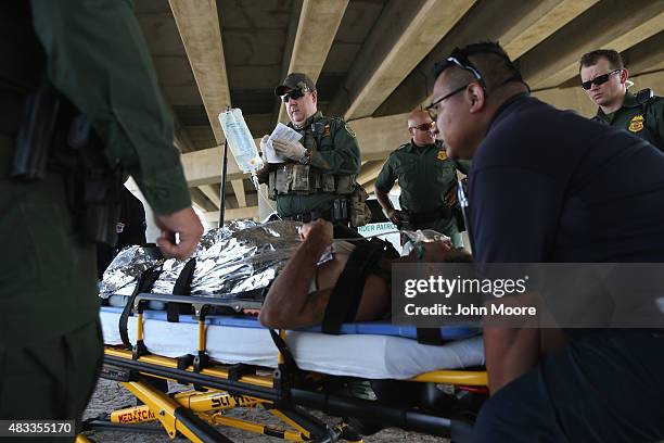 Paramedics and U.S. Border Patrol agents assist an undocumented immigrant after he collapsed from heat exhaustion after crossing from Mexico into the...