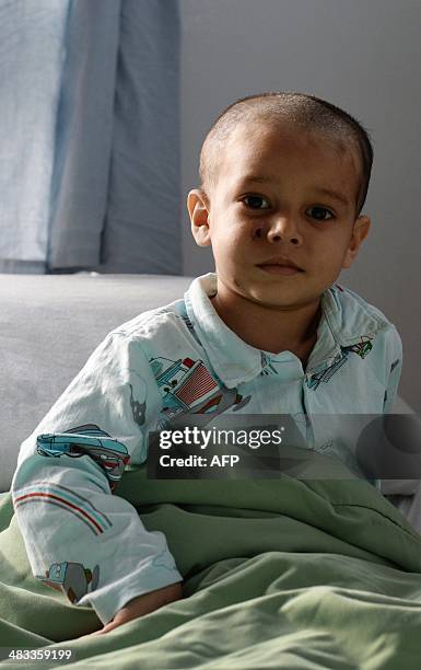 In this photograph taken on April 6 Abuzar Ahmad, the youngest son of slain Afghan AFP reporter Sardar Ahmad, sits in bed during a visit by family...