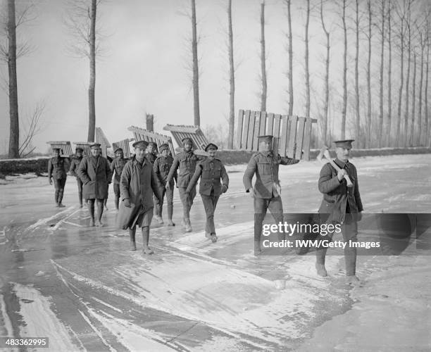 The British Army On The Western Front, March 1917, Members of a Royal Garrison Artillery working party carrying duck-boards across the frozen Somme...