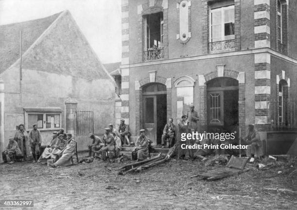 German troops sitting on the steps of the Vareddes Town Hall, France, 1914. German soldiers taking a rest during the First Battle of the Marne.