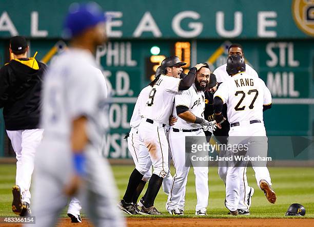 Pedro Alvarez of the Pittsburgh Pirates is congratulated by teammates including Francisco Cervelli and Jung Ho Kang following his walk off...