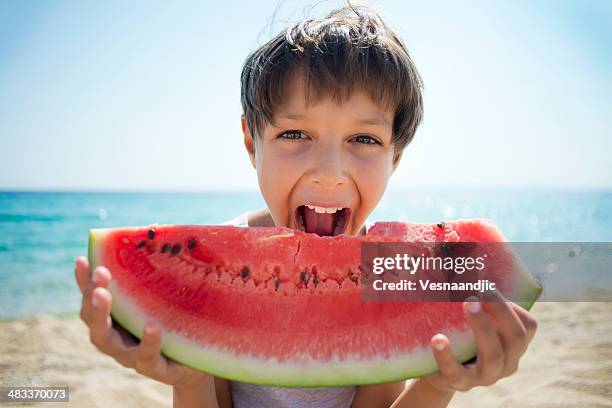 ragazzo mangiando anguria - anguria foto e immagini stock