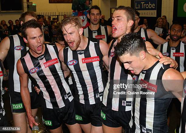 Matt Scharenberg, Jonathon Marsh, Darcy Moore and Brayden Maynard of the Magpies sing the song in the rooms after winning the round 19 AFL match...