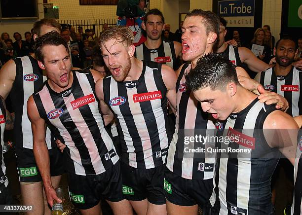 Matt Scharenberg, Jonathon Marsh, Darcy Moore and Brayden Maynard of the Magpies sing the song in the rooms after winning the round 19 AFL match...