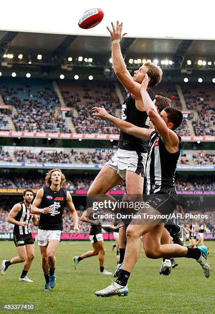 Lachie Henderson of the Blues attempts to mark as Scott Pendlebury of the Magpies applies pressure during the round 19 AFL match between the...