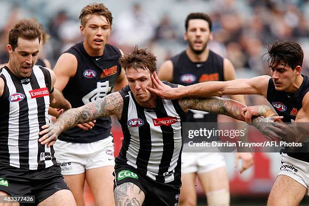 Dane Swan of the Magpies chases the ball as Blaine Boekhorst of the Blues applies pressure during the round 19 AFL match between the Collingwood...