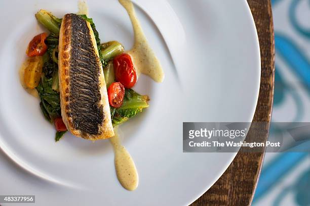 The Orata dish features dorade fish placed on a bed of romaine and cherry tomatoes in a brown butter at Masseria in Washington, DC, on Friday, July...