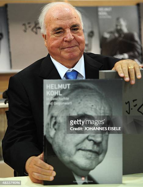 Former German Chancellor Helmut Kohl poses with a photo book about him at the book fair in Frankfurt, central Germany, on October 8, 2010. The 62nd...