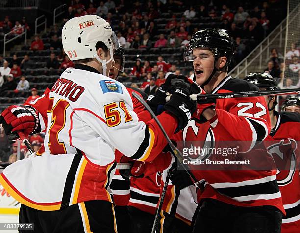 Ken Agostino of the Calgary Flames tangles with Eric Gelinas of the New Jersey Devils at the Prudential Center on April 7, 2014 in Newark, New...