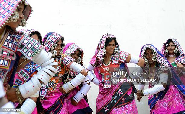 Indian Lambadi tribal women dance during a performance in Hyderabad on the eve of International Day of the World's Indigenous Peoples on August 8,...