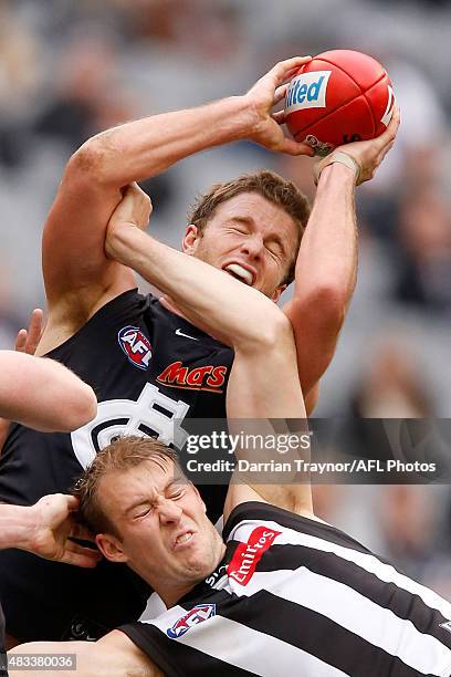 Lachie Henderson of the Blues marks the ball over Ben Reid of the Magpies during the round 19 AFL match between the Collingwood Magpies and Carlton...