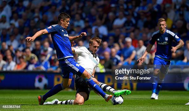 Fulham defender Dan Burn is challenged by Cardiff striker Alex Revell during the Sky Bet Championship match between Cardiff City and Fulham at...