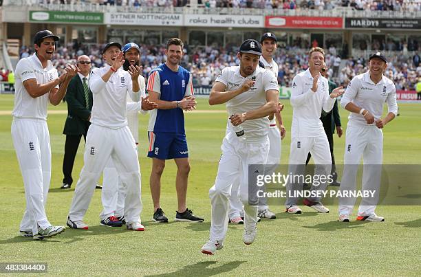 England bowler Mark Wood celebrates with teammates on the pitch after England wrap up the game and retain the Ashes on the third day of the fourth...