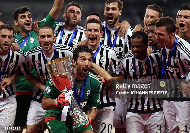 Juventus Italian goalkeeper Gianluigi Buffon celebrates his team victory with the trophy after the Italian Super Cup final football match between...