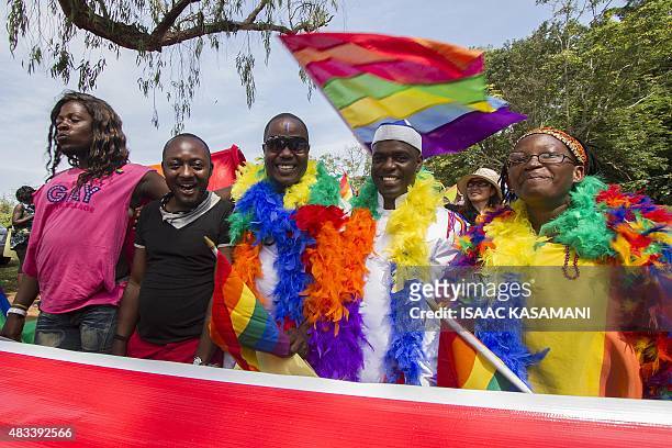 People hold rainbow flags as they take part in the Gay Pride parade in Entebbe on August 8, 2015. Ugandan activists gathered for a gay pride rally,...