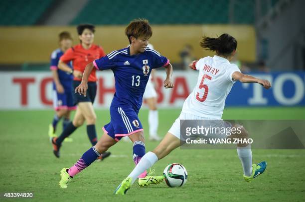 Mai Kyokawa of Japan fights for the ball with Wu Haiyan of China during their women's East Asian Cup football match at the Wuhan Sports Center...