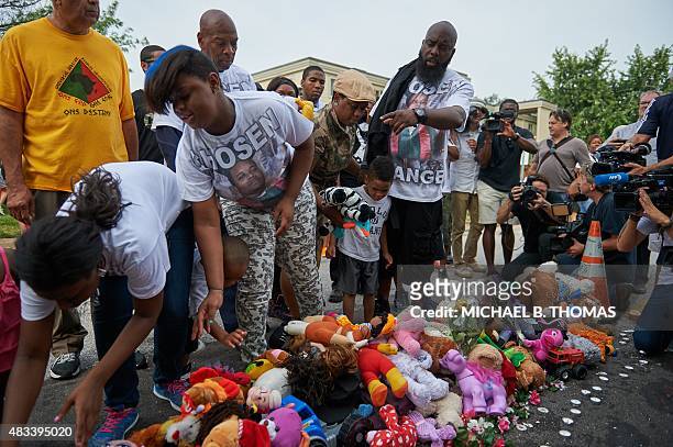 Michael Brown Sr., father of slain 18 year-old Michael Brown Jr. Points to stuffed animals along with Brown family members prior to a march of...