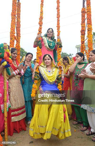 College girls wear traditional Punjabi dress riding 'Peeing' during the celebrations of Teej festival arranged at Khalsa College for Women on August...