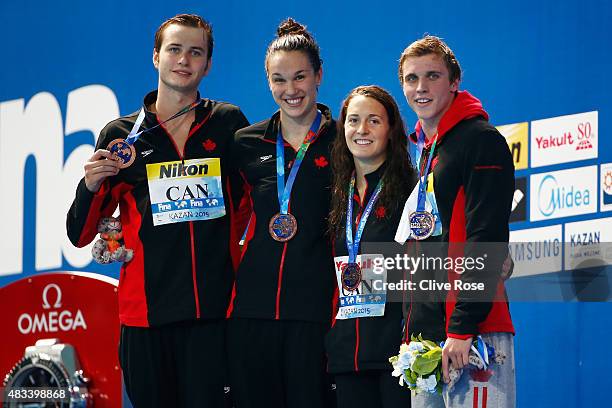 Bronze medallists Yuri Kisil, Chantal Van Landeghem, Sandrine Mainville and Santo Condorelli of Canada pose during the medal ceremony for the Mixed...