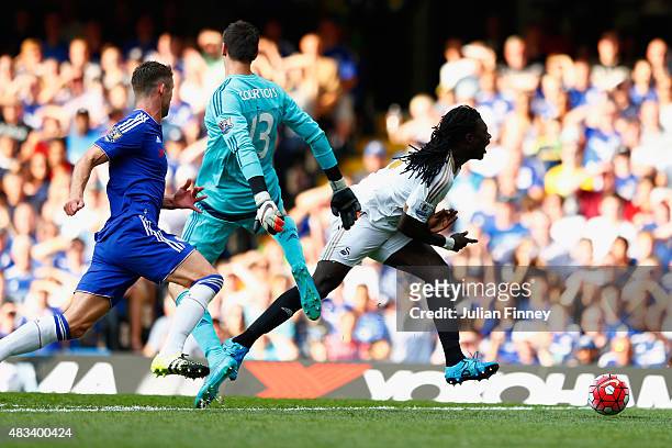 Bafetimbi Gomis of Swansea City is brought down by Thibaut Courtois of Chelsea resulting in a penalty during the Barclays Premier League match...