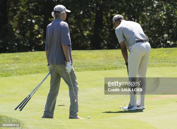 President Barack Obama hits a putt alongside comedian Larry David as they play golf at Farm Neck Golf Club in Oak Bluffs on Martha's Vineyard in...