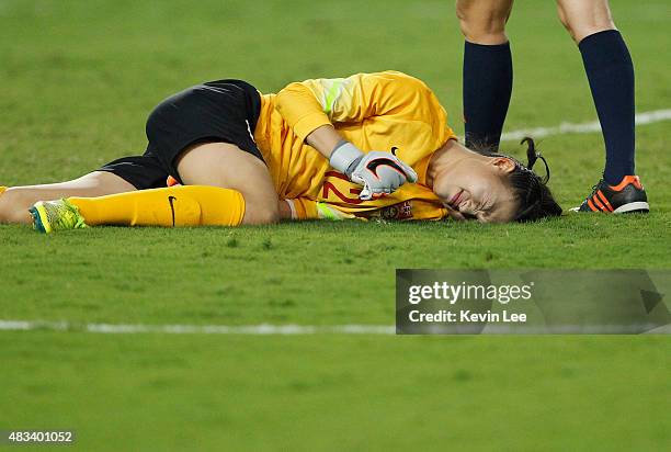 Wang Fei of China PR lies on the ground after a collision during the EAFF East Asian Cup 2015 final round against Japan at the Wuhan Sports Center...