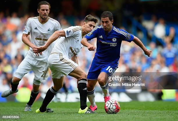 Eden Hazard of Chelsea and Federico Fernandez of Swansea City compete for the ball during the Barclays Premier League match between Chelsea and...
