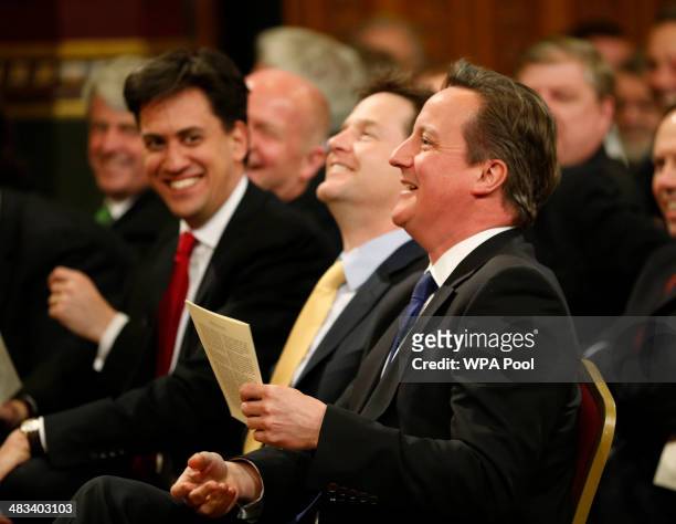 British Prime Minister David Cameron accompanied by Labour party leader Ed Miliband and Deputy Prime Minister Nick Clegg laugh as they wait for the...
