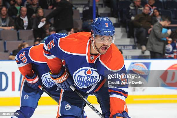 Mark Fraser of the Edmonton Oilers lines up for a face off in a game against the San Jose Sharks on March 25, 2014 at Rexall Place in Edmonton,...