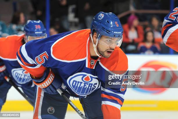 Mark Fraser of the Edmonton Oilers lines up for a face off in a game against the San Jose Sharks on March 25, 2014 at Rexall Place in Edmonton,...