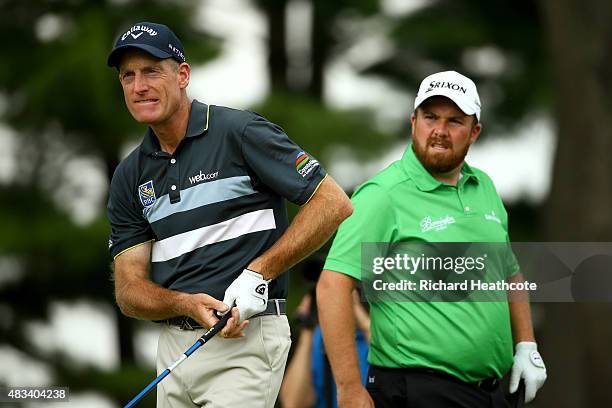 Jim Furyk hits off the fourth tee as Shane Lowry of Ireland looks on during the third round of the World Golf Championships - Bridgestone...