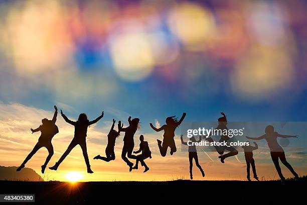 so energic friends jumping at sunset - group excitement stock pictures, royalty-free photos & images
