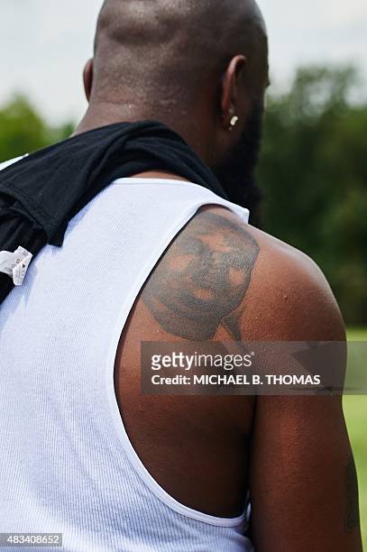 Tattoo of Michael Brown Jr. Is seen on the shoulder of Michael Brown Sr. Father of the slain 18 year-old during a march of solidarity at Normandy...