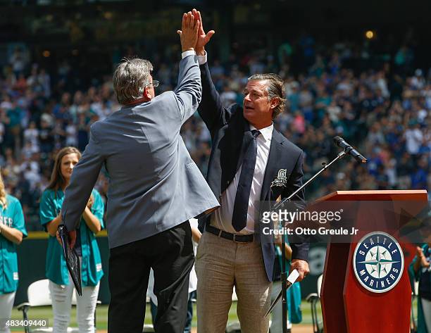 Former Seattle Mariners pitcher Jamie Moyer gets a high-five from Mariners broadcaster Rick Rizzs during ceremonies inducting him into the Seattle...