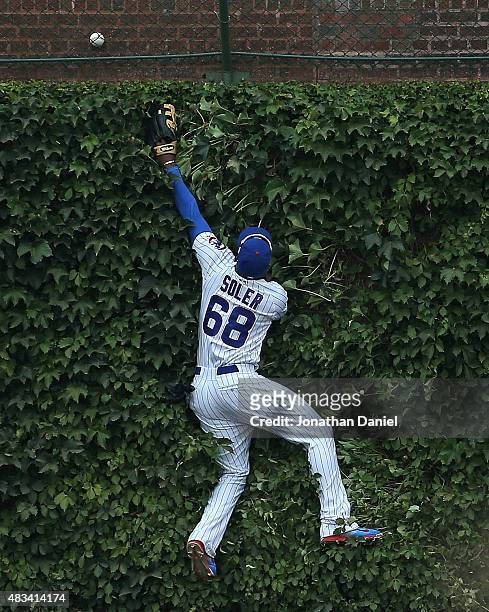 Jorge Soler of the Chicago Cubs jumps up against the outfield wall trying to catch a home run ball hit by Brandon Belt of the San Francisco Giants in...