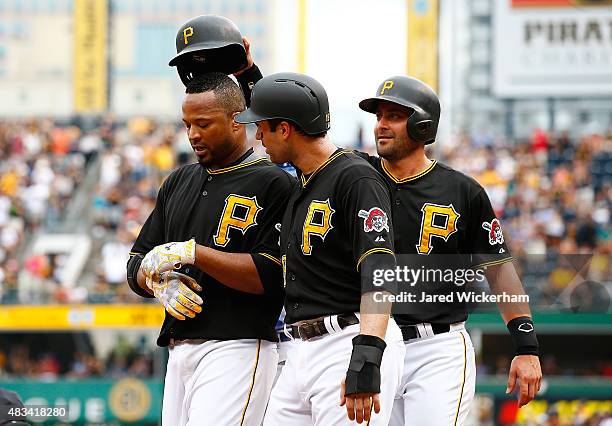 Francisco Liriano of the Pittsburgh Pirates is congratulated by teammates Neil Walker and Francisco Cervelli after hitting a three run home run in...